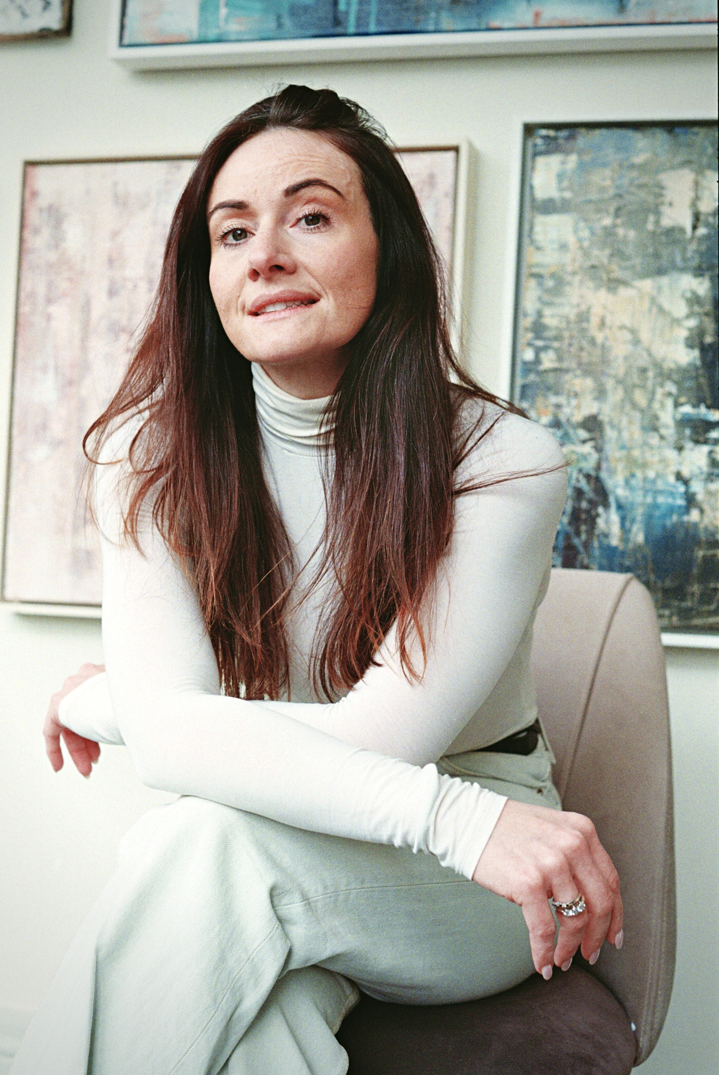 Sarah-Jane seated portrait with abstract art behind her