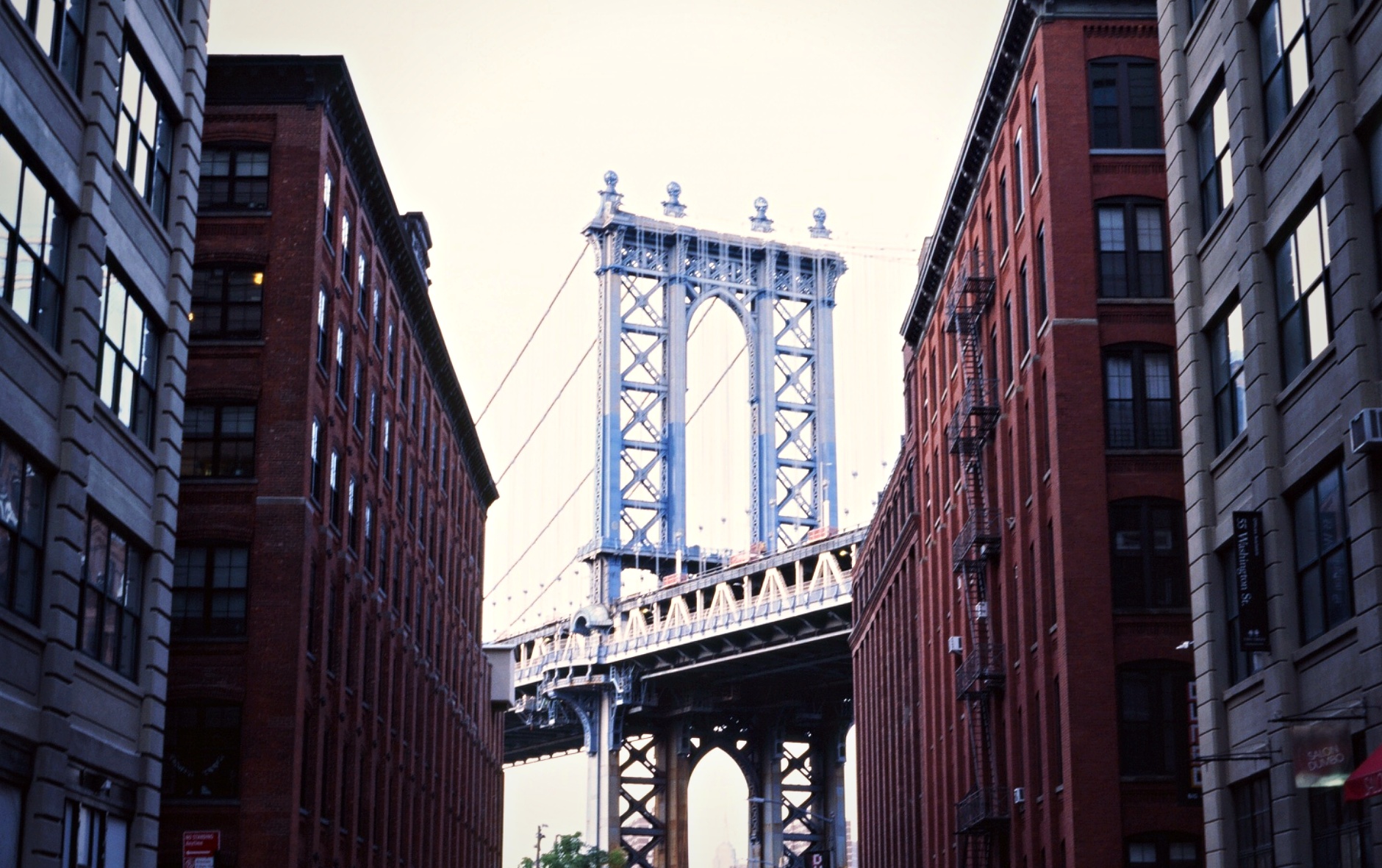 Manhattan Bridge framed between DUMBO brick buildings Brooklyn New York — architectural film photography
