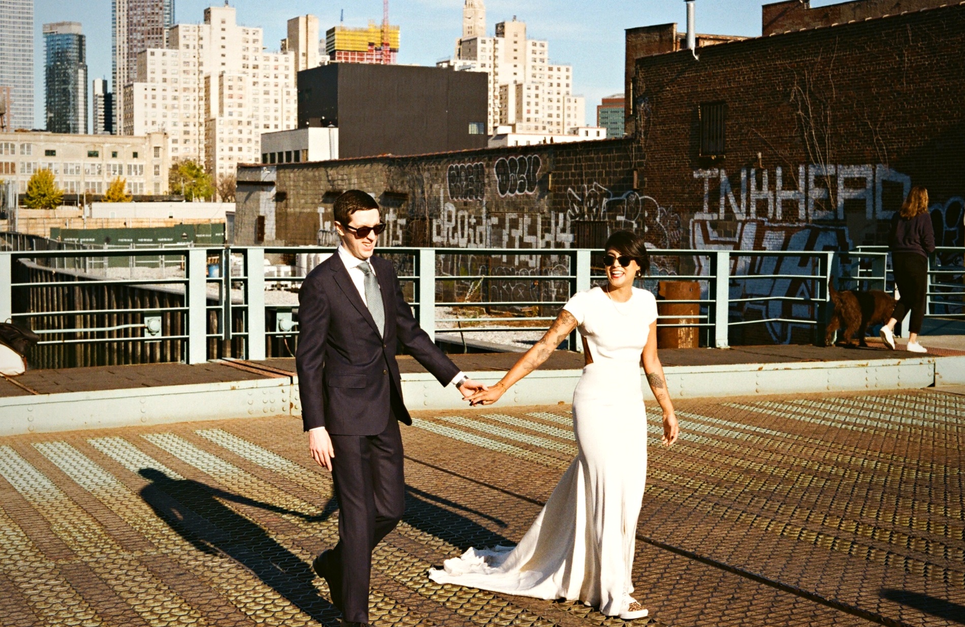 Couple walking hand in hand on Brooklyn pier with NYC skyline — analogue film