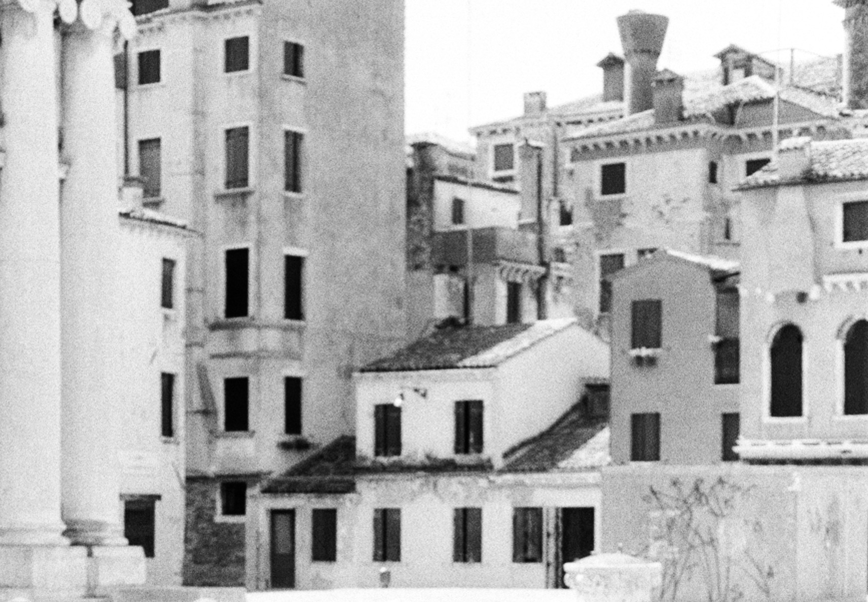 The rooftops and chimneys behind the gondolas, rendered soft and high-key in shallow focus.