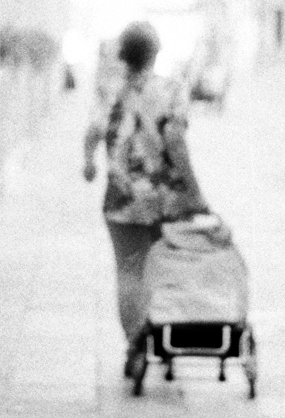 The same figure enlarged until she breaks into grain, reading as a drawn mark rather than a photograph.
